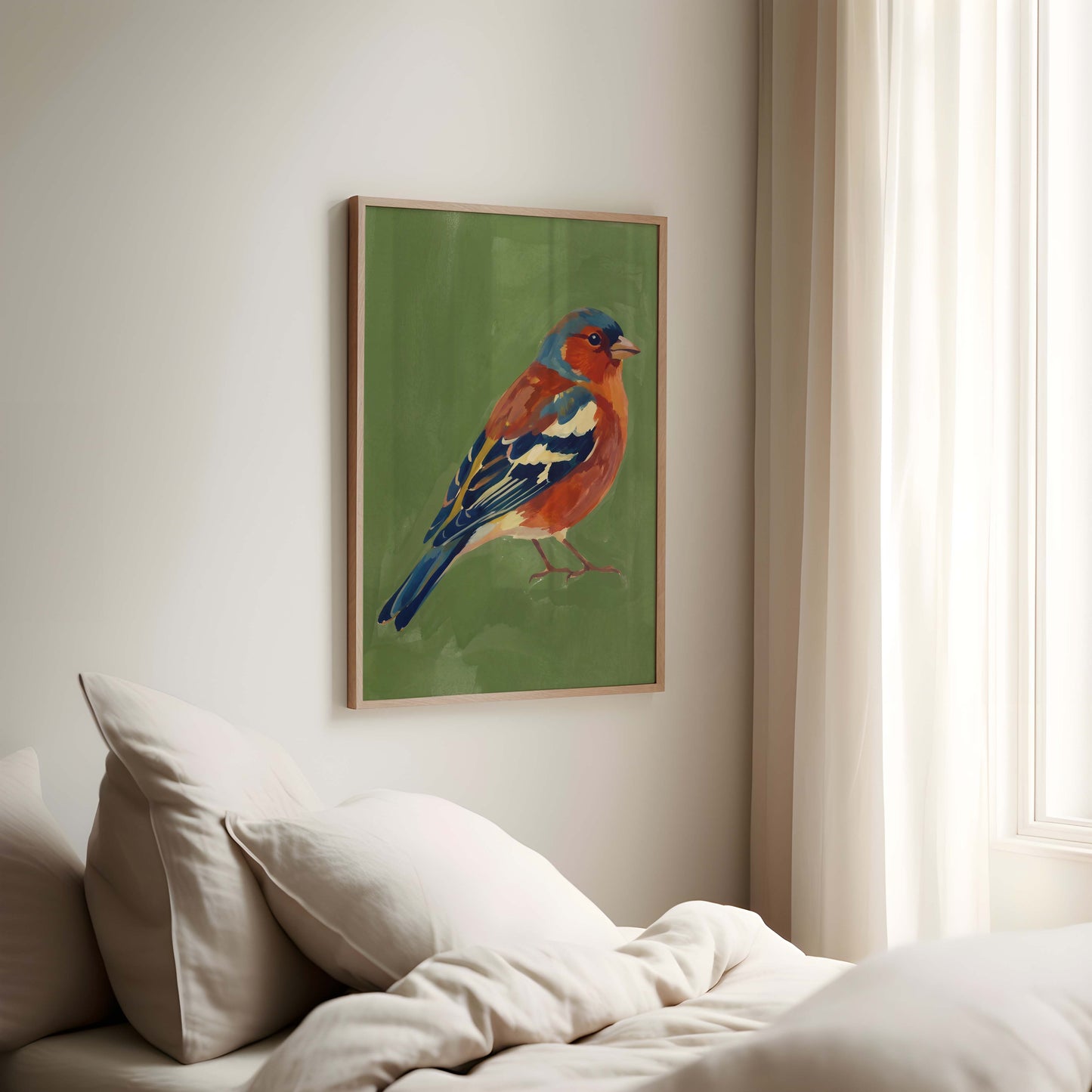 A framed art print of a bluebird on a green background, hanging on a beige wall above a bed with neutral-colored bedding and pillows.