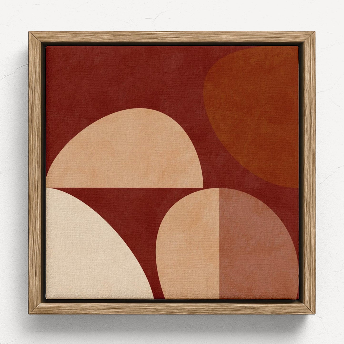 Framed abstract wall art featuring geometric shapes in terracotta, rust, cream, and tan on a white background.