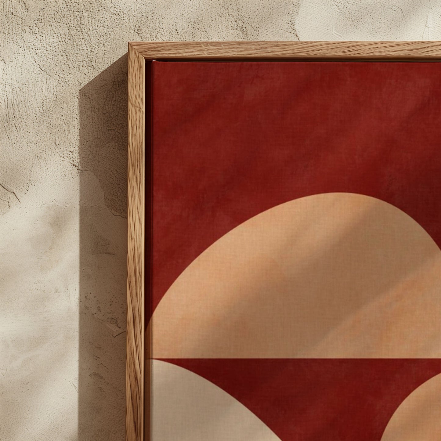 Framed abstract wall art with a bold red background and large beige and white curved geometric shapes, shown leaning against a textured beige wall.