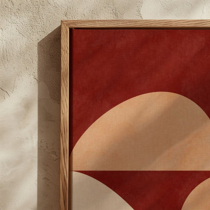 Framed abstract wall art with a bold red background and large beige and white curved geometric shapes, shown leaning against a textured beige wall.