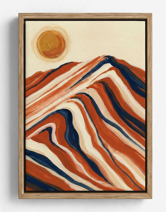 Framed abstract landscape painting featuring wavy mountain-like forms in terracotta, cream, and navy, with a circular sun in the upper left, shown against a light wall.