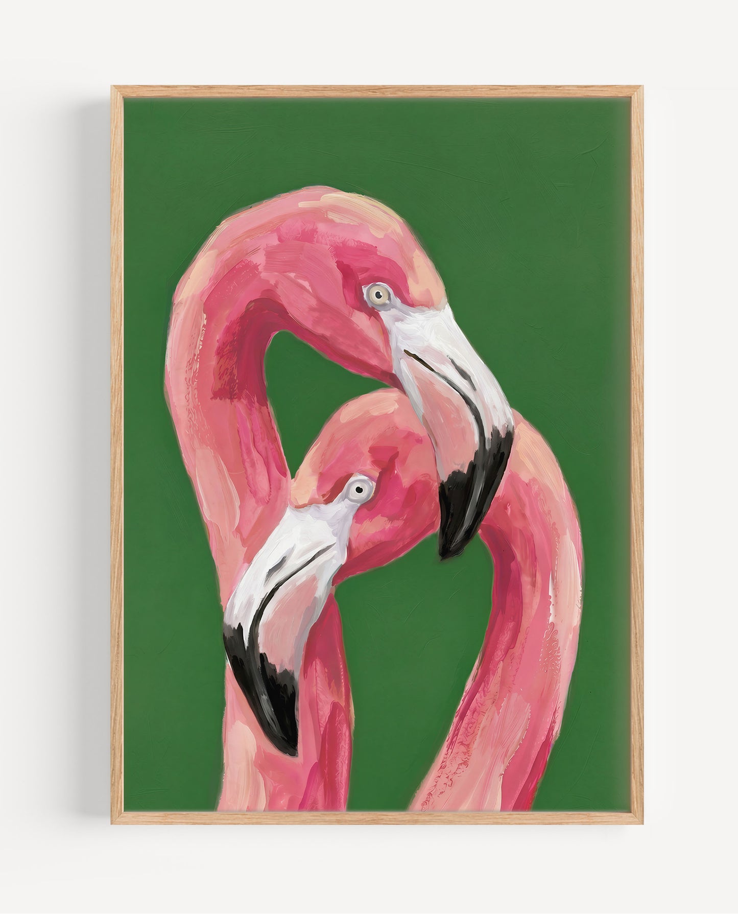 A framed art print featuring a painted pink flamingo against a solid green background, enclosed in a light natural wood frame and shown hanging on a white wall.