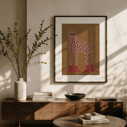 Framed artwork of a stylized cat on a wall above a wooden console table with decor items.