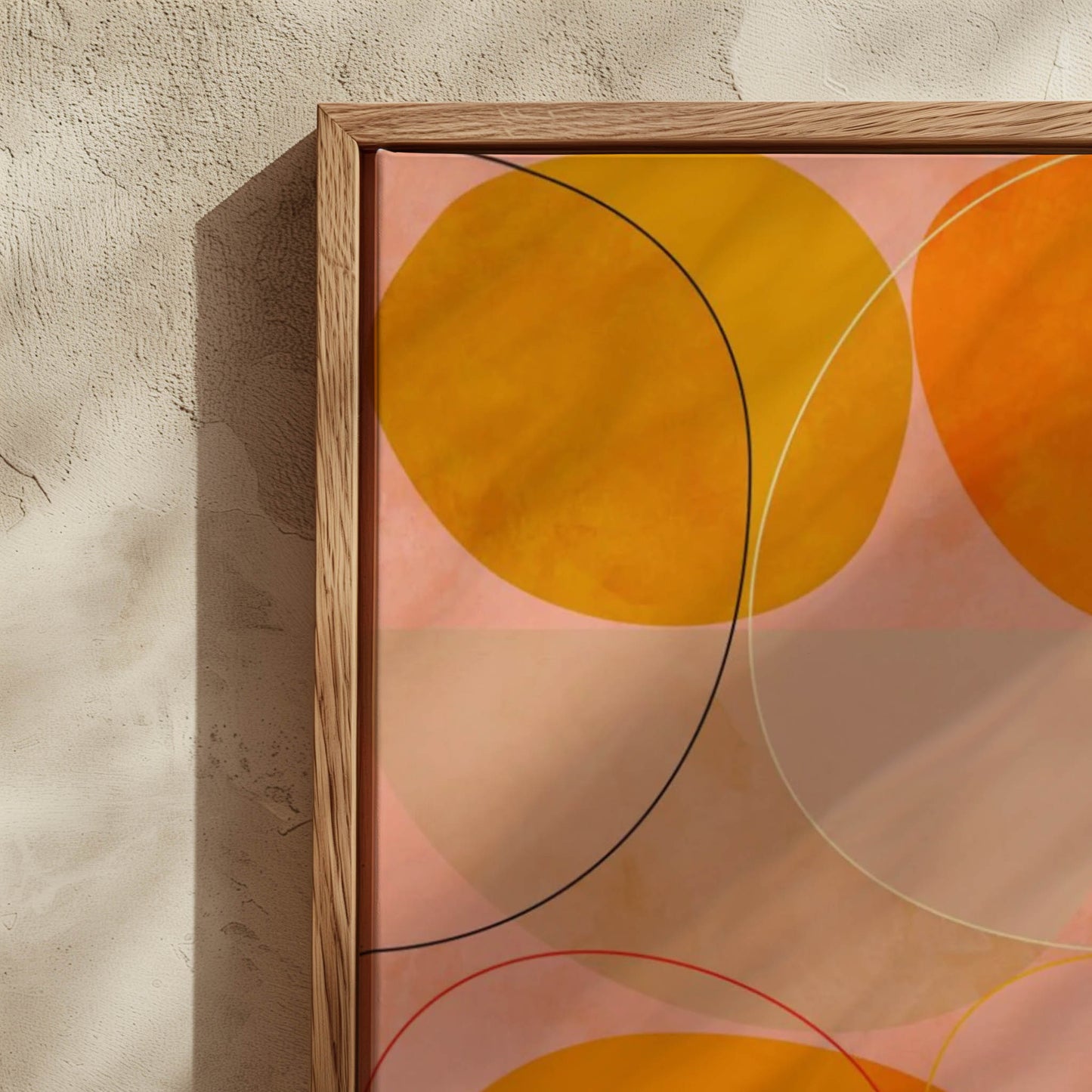 Framed abstract wall art with overlapping yellow, orange, and peach circles outlined in thin black and white lines, set in a light wood frame against a textured beige wall.