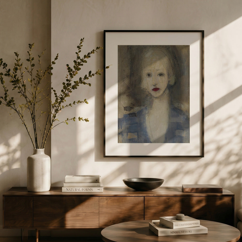 A framed portrait print hangs on a beige wall above a wooden console table in a styled interior. The artwork shows a woman with soft painterly brushstrokes, muted blue clothing, and pale skin tones.