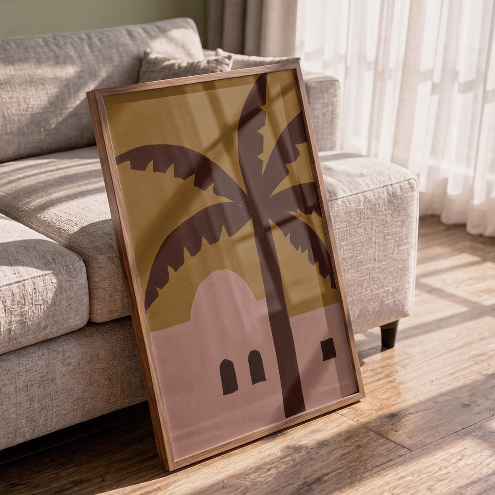 Framed artwork with palm trees and a building on a wooden floor in a living room.