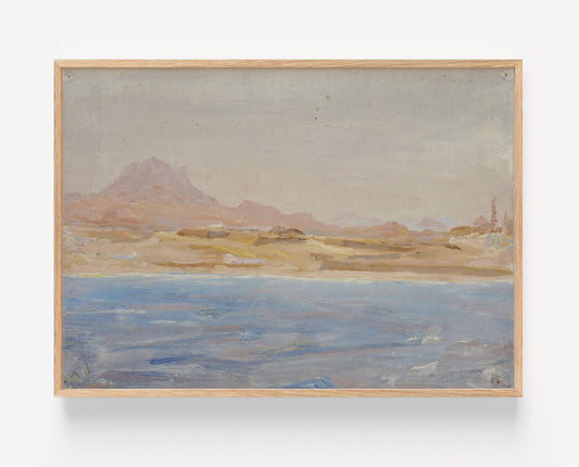A framed landscape painting featuring a muted blue body of water in the foreground, sandy beige marshland, distant brown mountains, and a pale sky, enclosed in a light natural wood frame against a white wall.