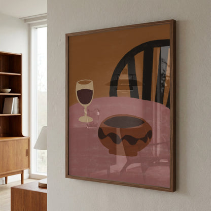 Framed abstract artwork of a wine glass and bowl on a wall in a room with furniture.