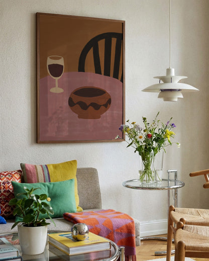 Living room with colorful decor, including a painting of a chair and wine glass, and a vase of flowers on a small table.