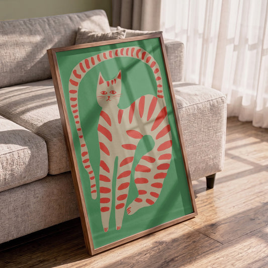 Framed artwork of a red and white striped cat on a green background in a living room.