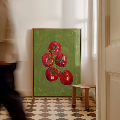 A framed painting of five red tomatoes on a green background, leaning against a white wall in a room with a checkered floor and a small wooden stool. A blurred person walks past on the left.